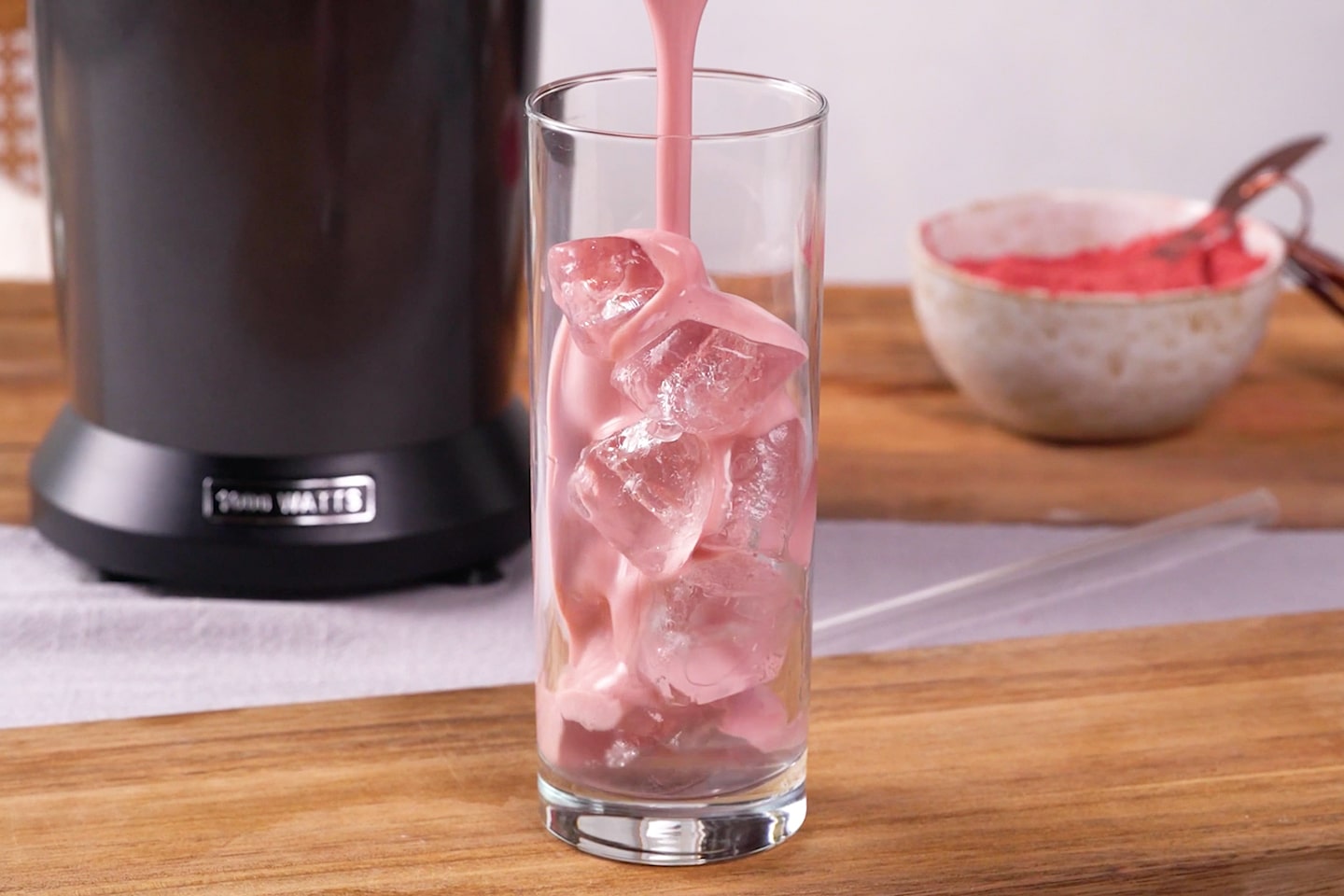 Dalgona Schaum-Kaffee mit Erdbeermilch und süßer Kaffeecreme als Topping oben auf der Milch in einem Glas mit Trinkhalm