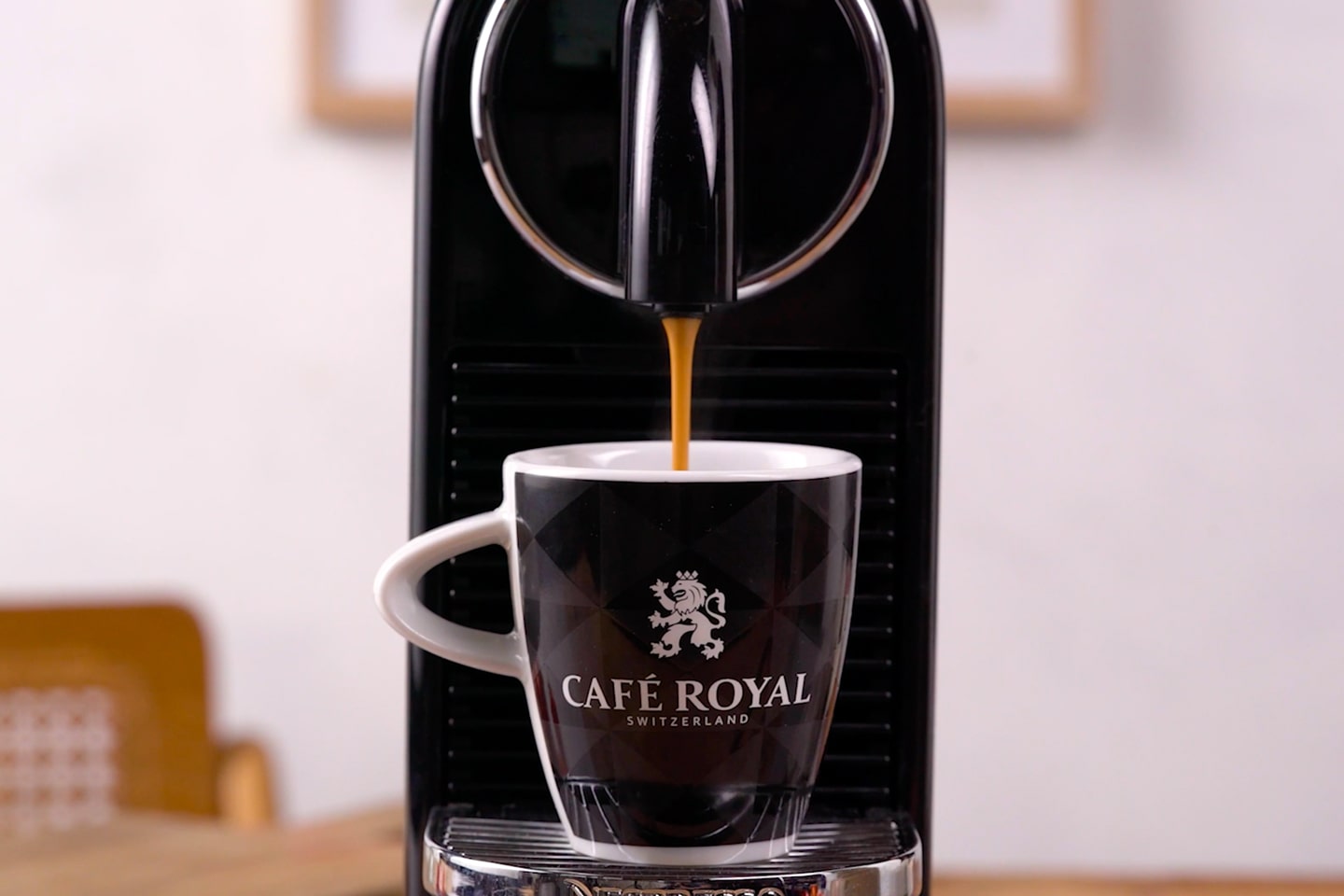 Een shot Café Royal Espresso Forte koffie stroomt smaakvol uit een capsulemachine in een espressokopje